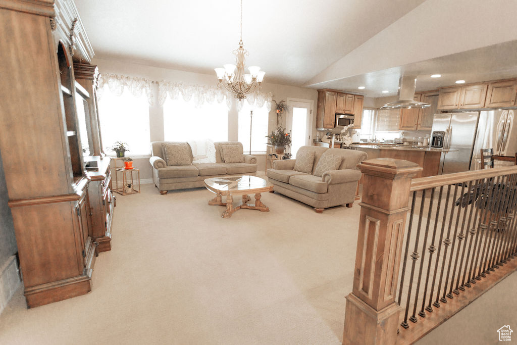 Living room featuring light carpet, plenty of natural light, vaulted ceiling, a chandelier, and recessed lighting