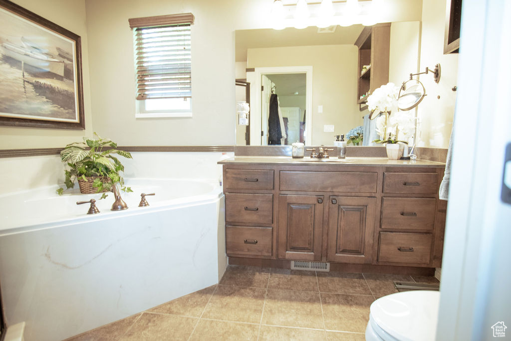 Bathroom with vanity, a garden tub, tile patterned floors, and toilet