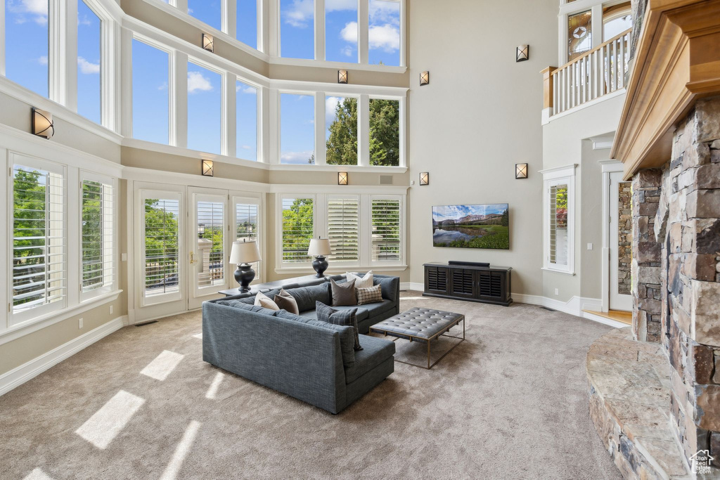 Living room featuring a high ceiling, carpet flooring, and baseboards