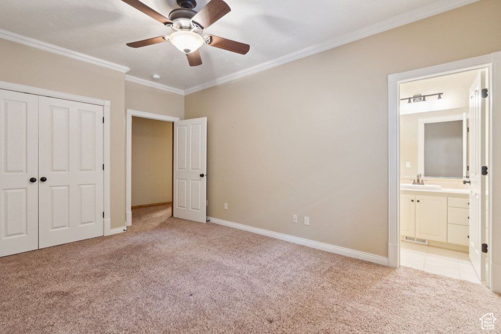 Unfurnished bedroom with carpet flooring, crown molding, a closet, connected bathroom, and baseboards
