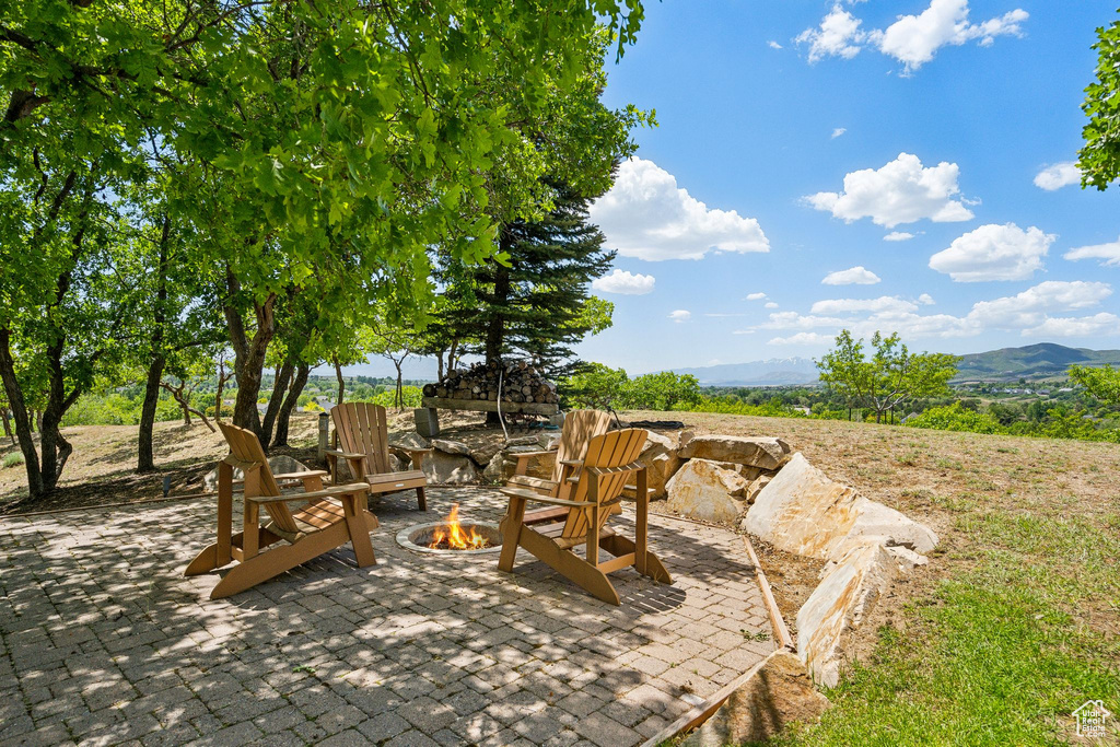 View of patio with an outdoor fire pit and a mountain view