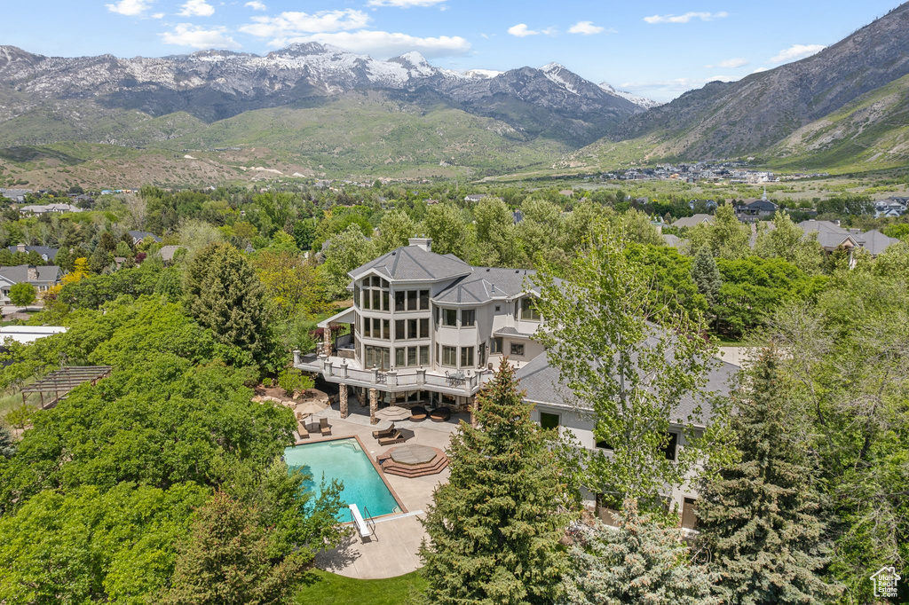 Aerial view of property and surrounding area featuring a pool area and a mountain backdrop