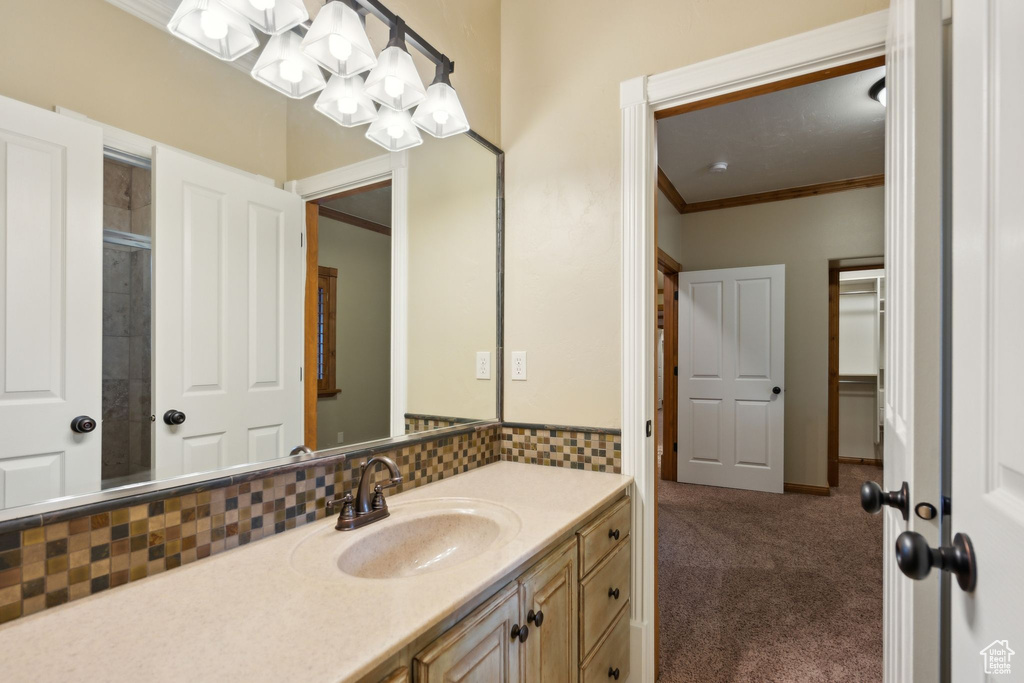 Bathroom with vanity, crown molding, and a chandelier