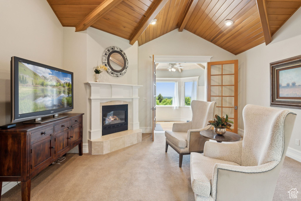 Living area featuring light colored carpet, wood ceiling, a premium fireplace, ceiling fan, and baseboards