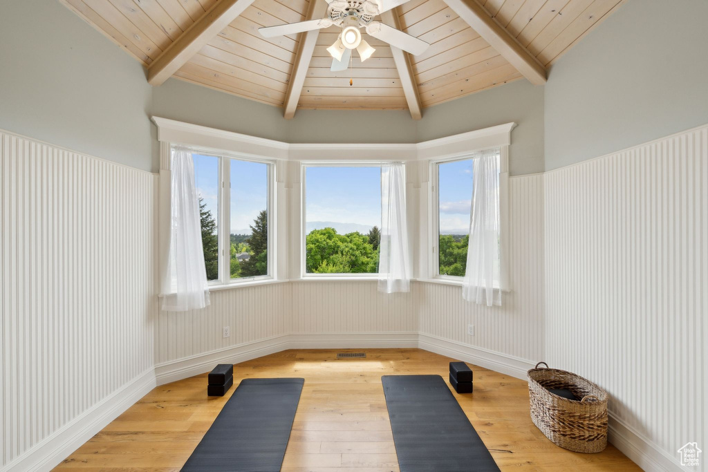 Exercise area with hardwood / wood-style flooring, a ceiling fan, healthy amount of natural light, wood ceiling, and lofted ceiling
