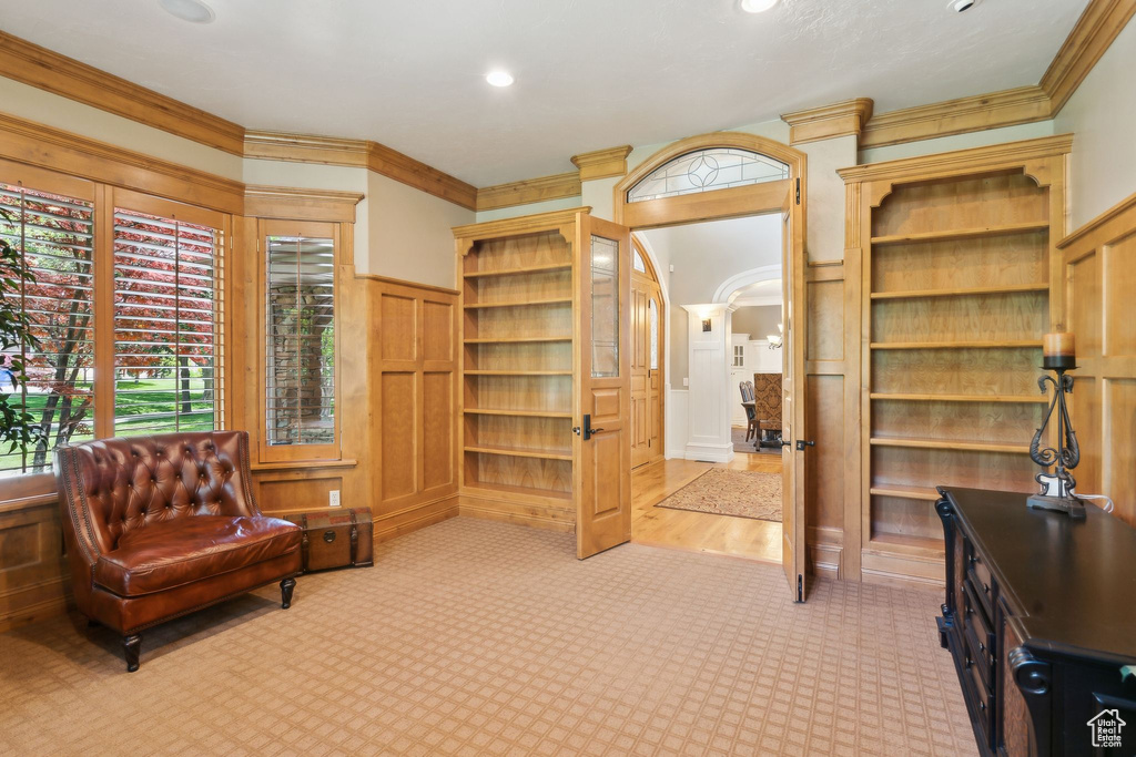 Living area with carpet, arched walkways, crown molding, and recessed lighting