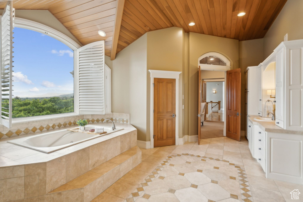 Full bathroom with tile patterned flooring, wood ceiling, lofted ceiling, a whirlpool tub, and vanity