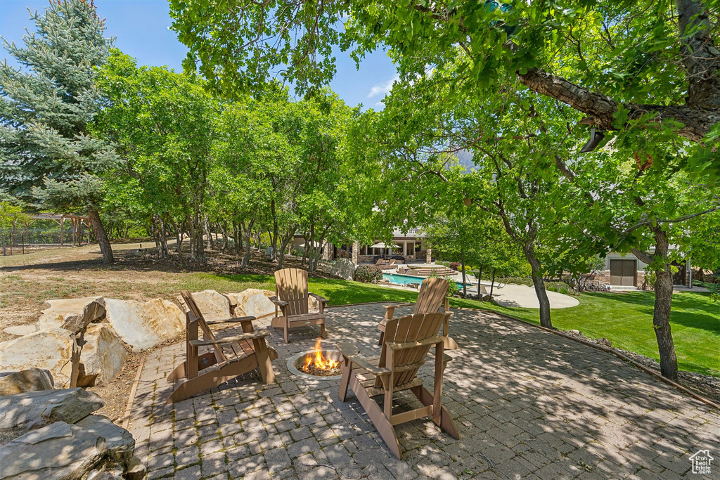 View of patio / terrace with a fire pit and a swimming pool