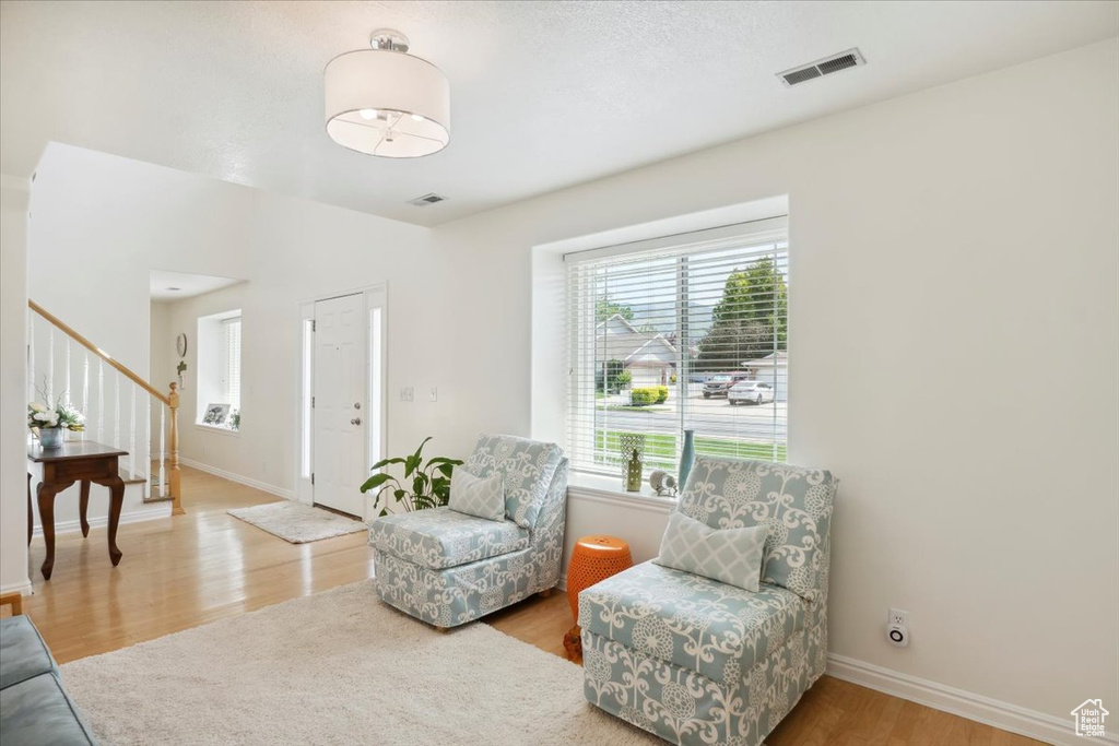 Sitting room featuring wood finished floors, stairs, and baseboards