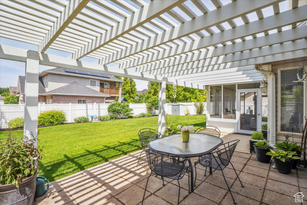 View of patio / terrace featuring a sunroom, outdoor dining area, and a pergola