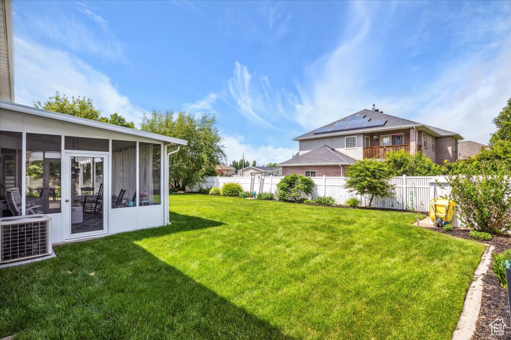 View of yard featuring central AC unit and a sunroom