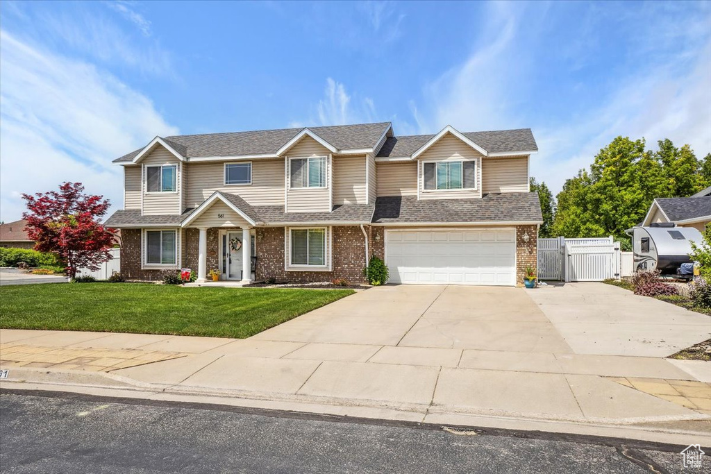 View of front of house featuring brick siding, driveway, a gate, a garage, and a shingled roof