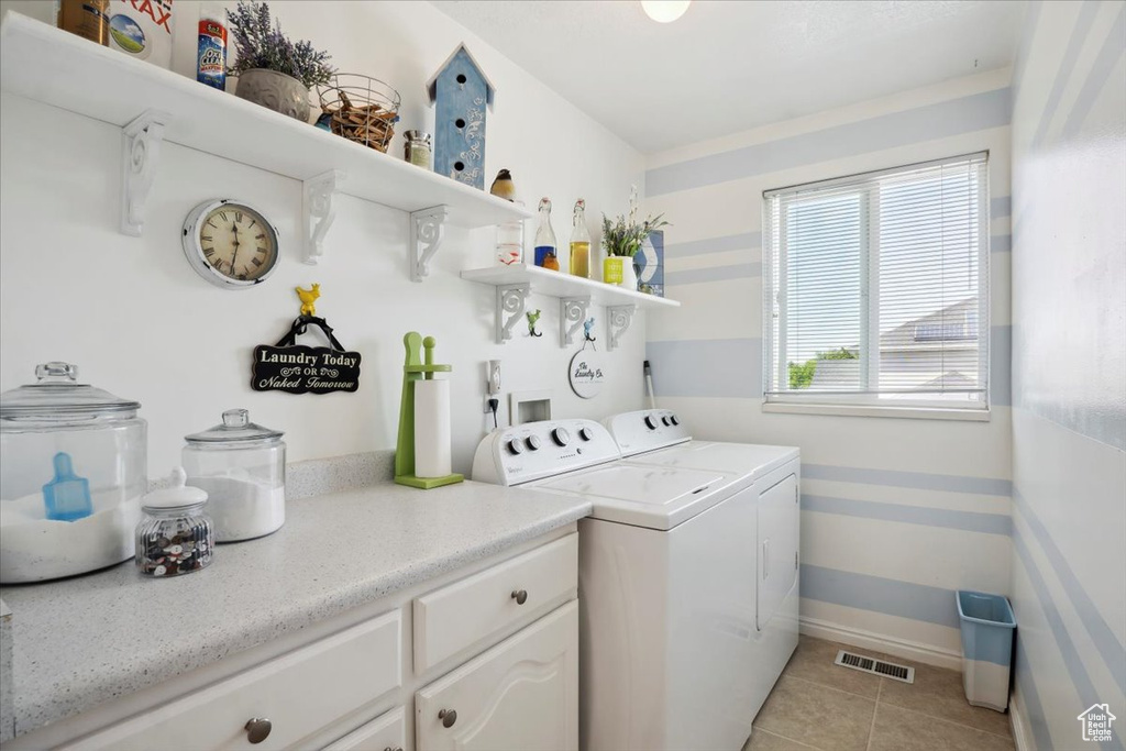 Washroom featuring washing machine and clothes dryer, light tile patterned floors, and baseboards