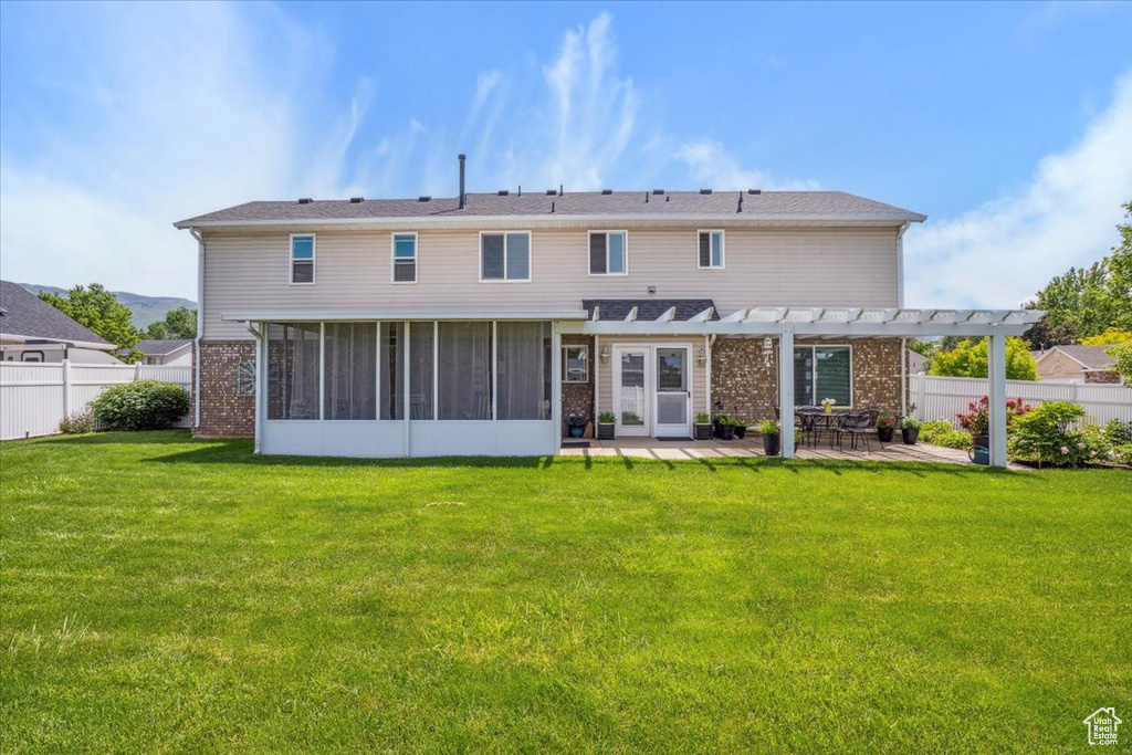 Back of property featuring a pergola, a sunroom, a patio, and brick siding