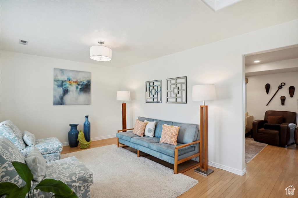 Living room with light wood-type flooring, baseboards, and recessed lighting