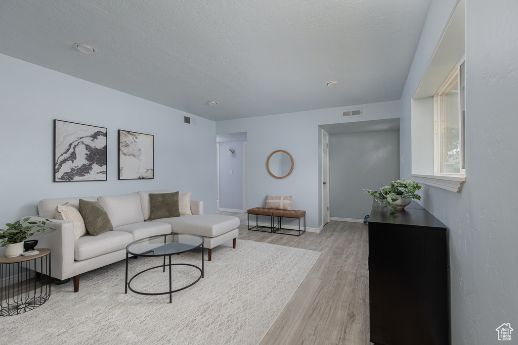 Living area featuring light wood-style floors and baseboards