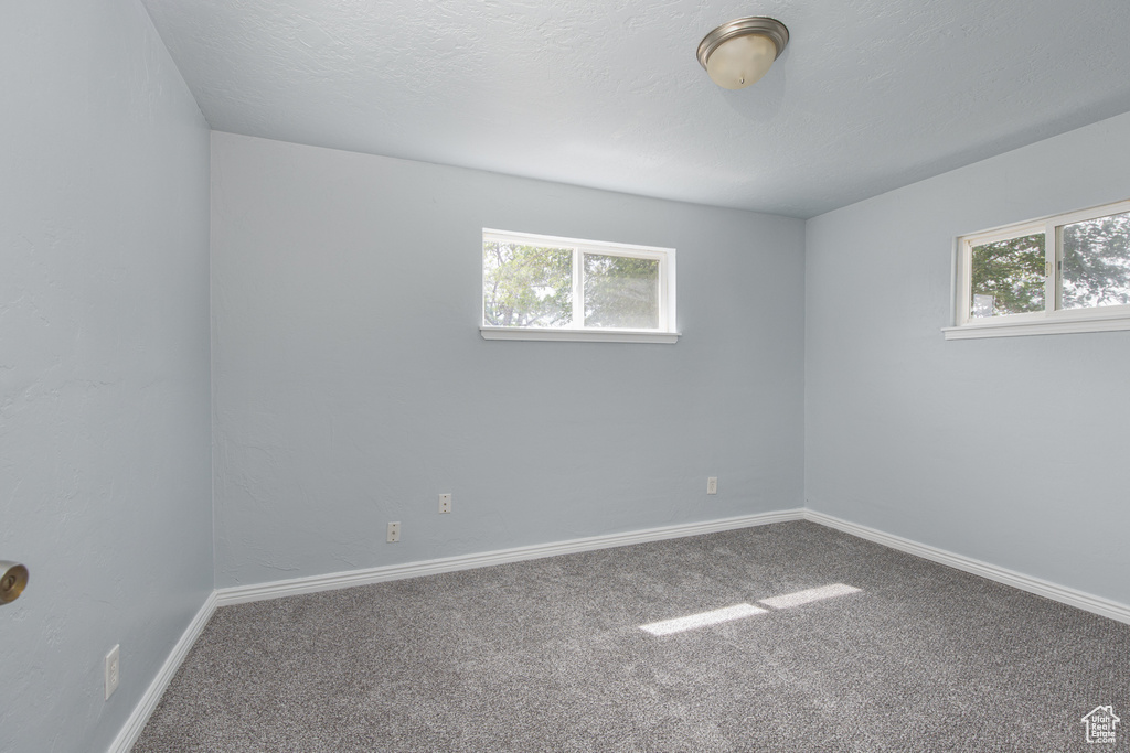 Empty room featuring carpet floors and baseboards