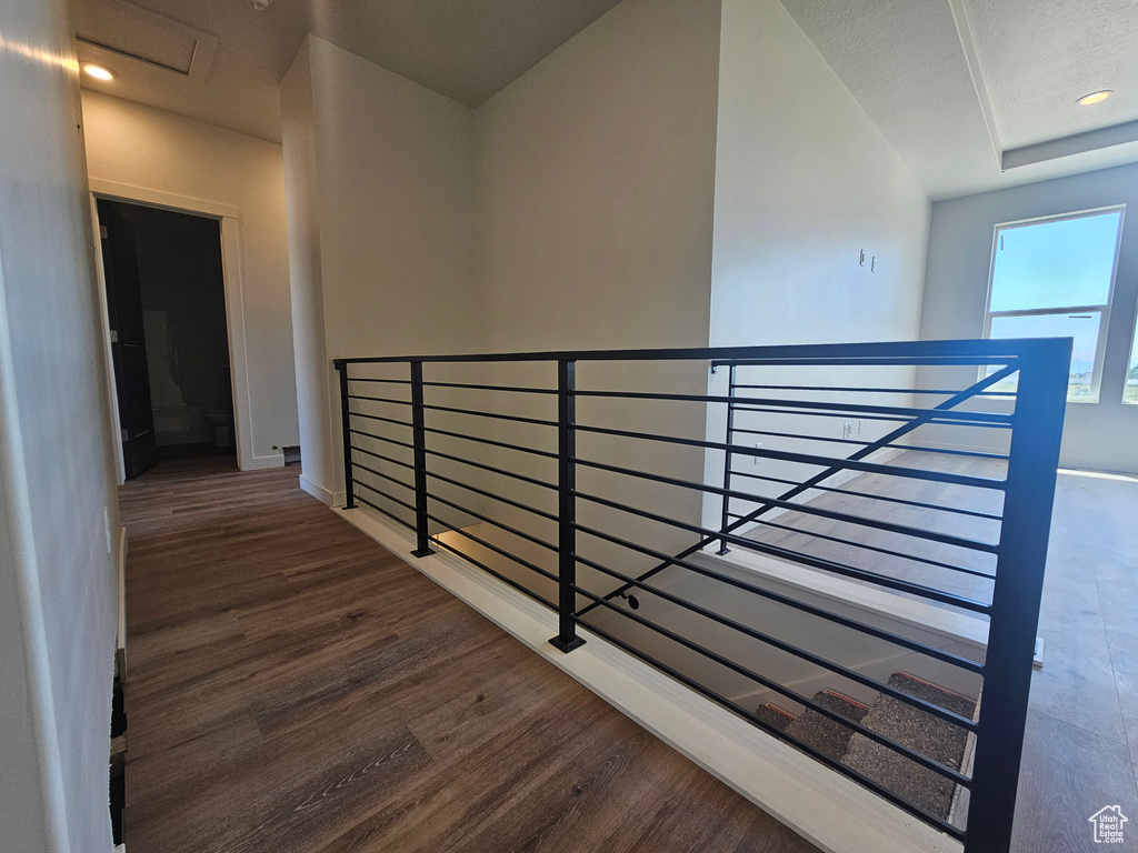 Hallway with an upstairs landing, wood finished floors, and baseboards