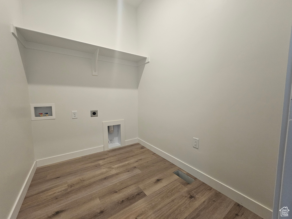 Laundry area with washer hookup, wood finished floors, baseboards, and electric dryer hookup