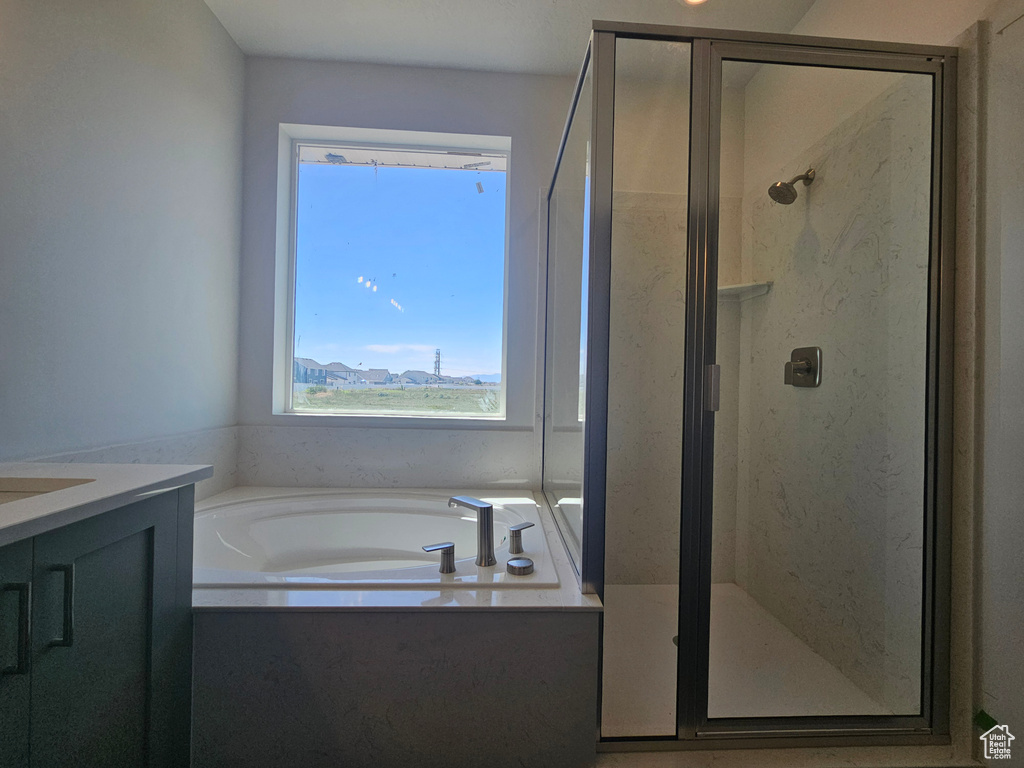Full bathroom with a shower stall, a garden tub, and vanity