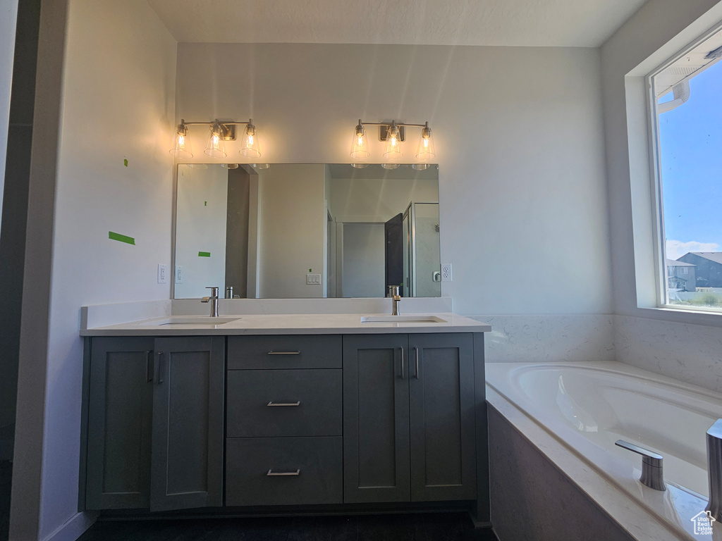 Full bathroom with double vanity, a garden tub, and a stall shower