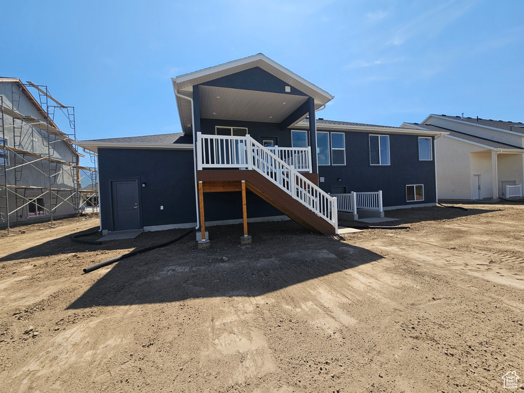 Back of property featuring stucco siding and stairway