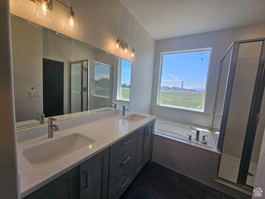 Full bathroom with a stall shower, a garden tub, double vanity, and tile patterned flooring