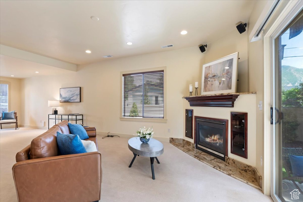 Living room featuring carpet flooring, a glass covered fireplace, healthy amount of natural light, and recessed lighting