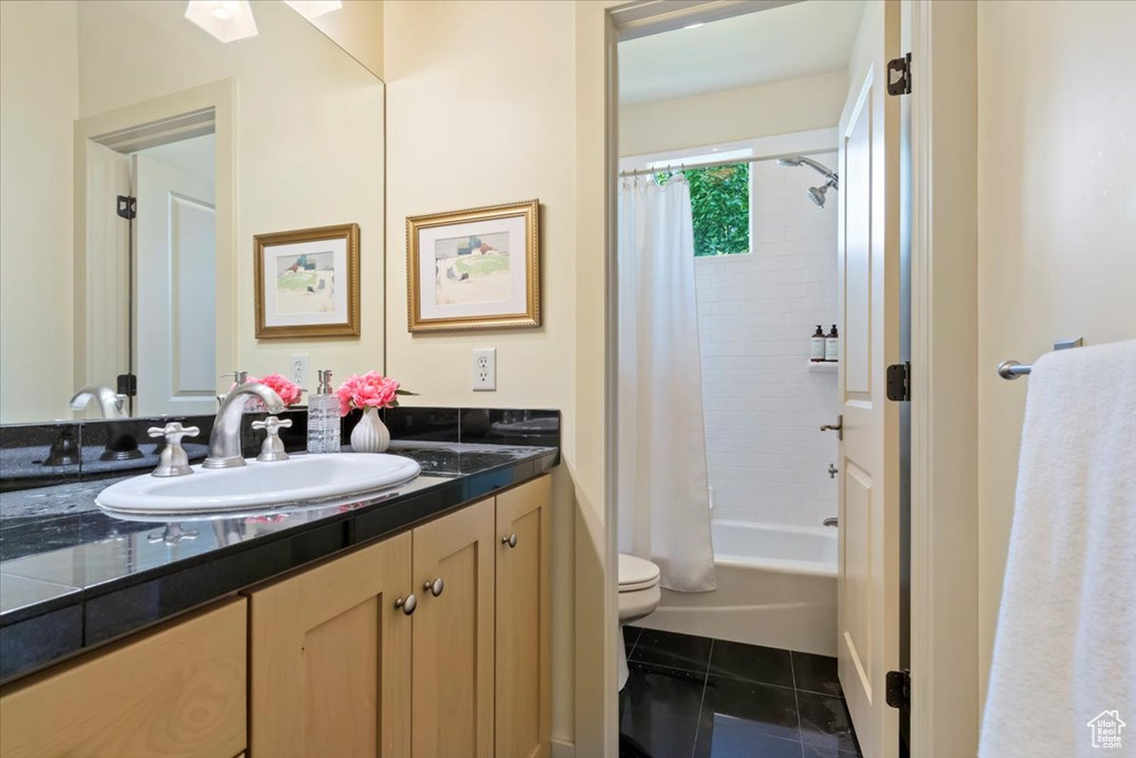 Bathroom with vanity, toilet, shower / bath combination with curtain, and tile patterned flooring