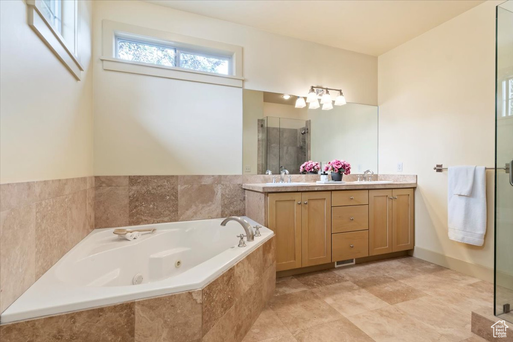 Full bathroom featuring a stall shower, double vanity, and a jetted tub