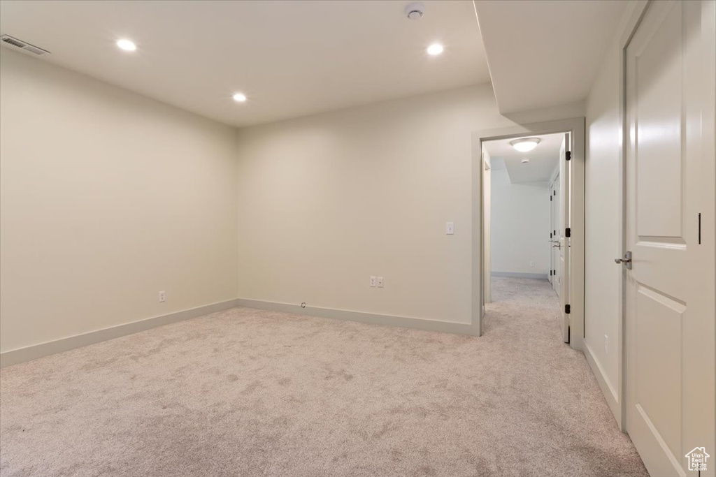 Empty room featuring light carpet, recessed lighting, and baseboards