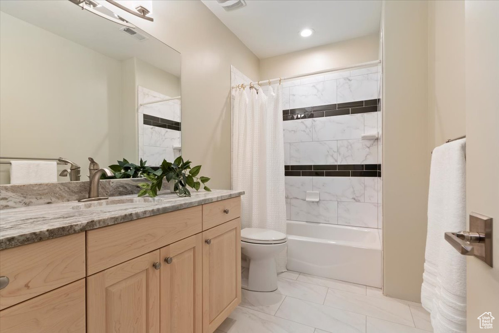 Bathroom featuring vanity, shower / bath combination with curtain, toilet, and marble look tile flooring