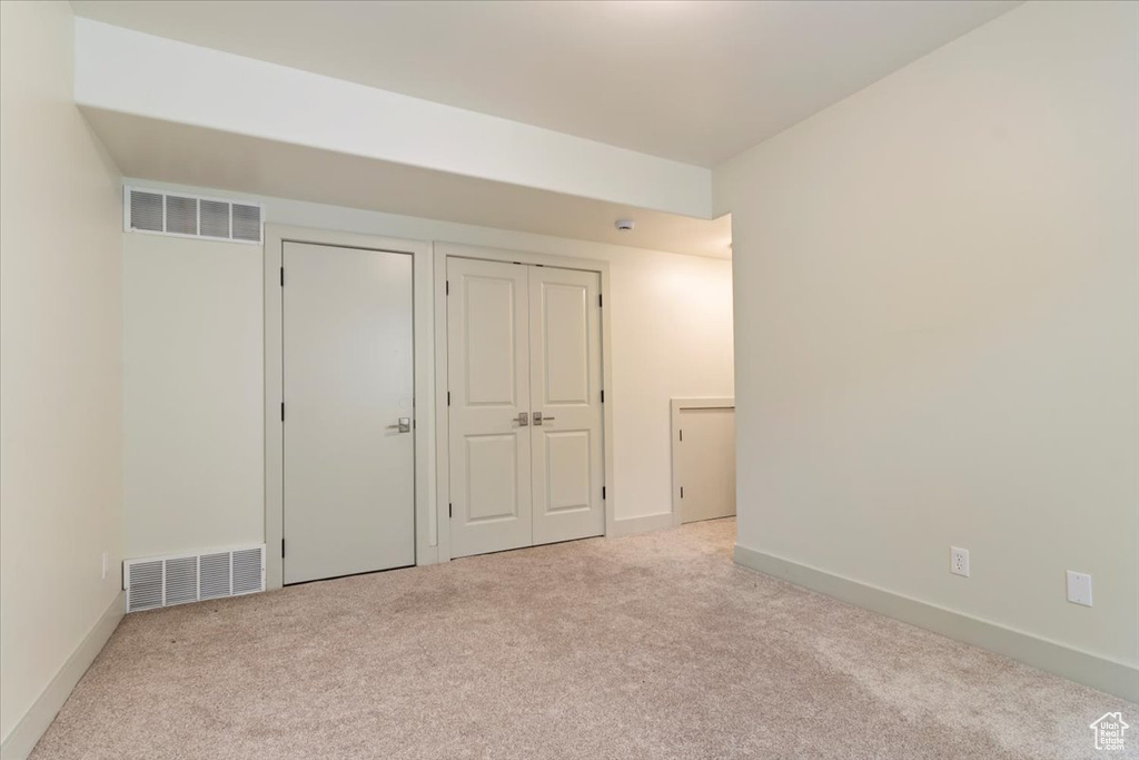 Unfurnished bedroom featuring carpet floors, two closets, and baseboards