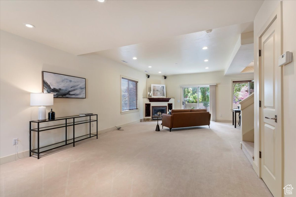 Living room featuring recessed lighting, carpet floors, baseboards, and a fireplace with raised hearth