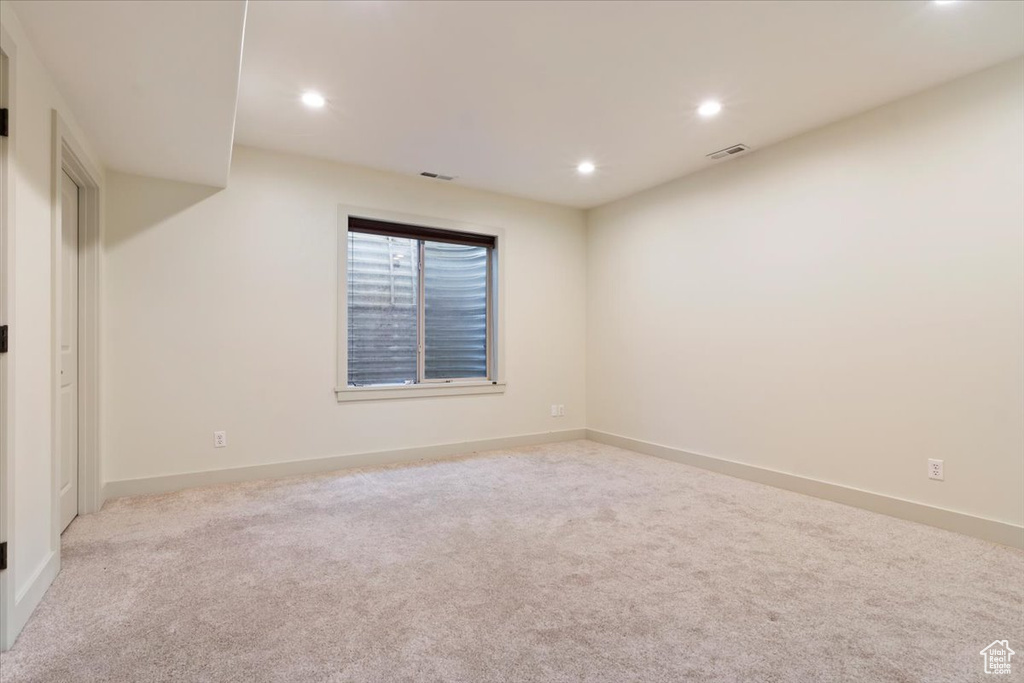 Carpeted empty room featuring recessed lighting and baseboards
