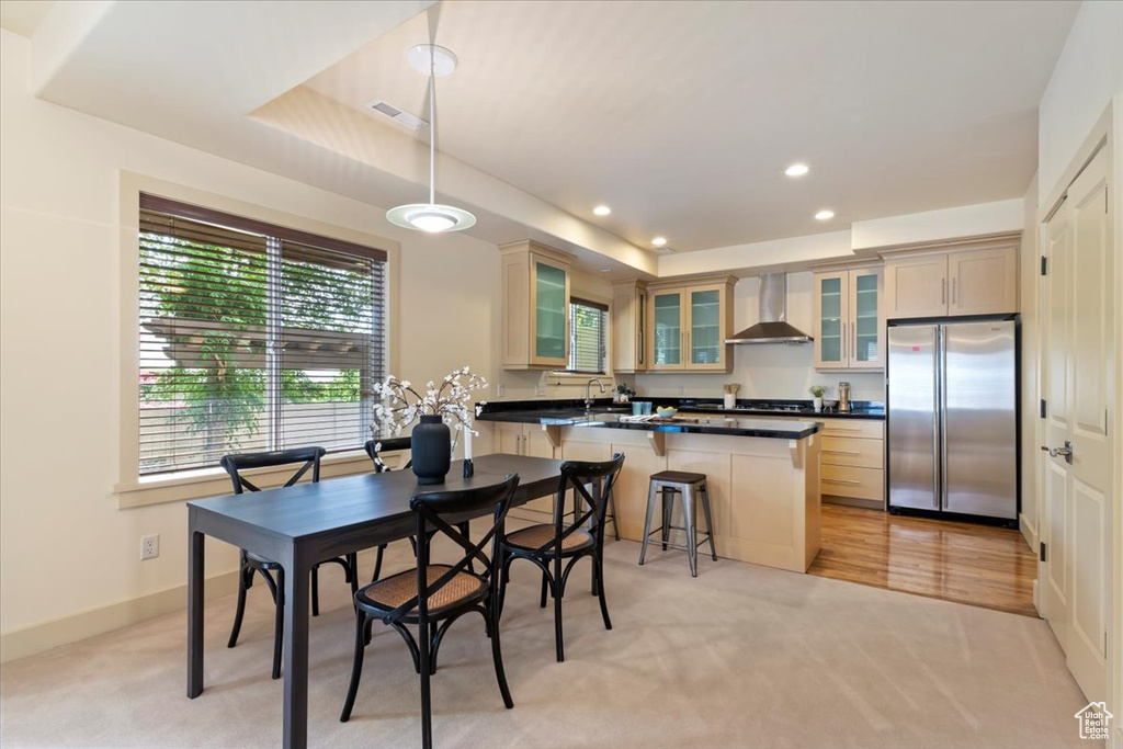 Dining space featuring light colored carpet, recessed lighting, a raised ceiling, and baseboards