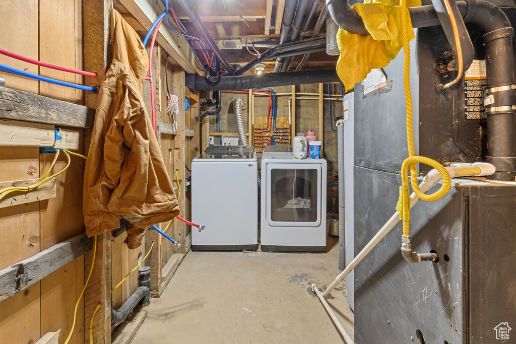 Unfinished below grade area featuring separate washer and dryer and heating unit