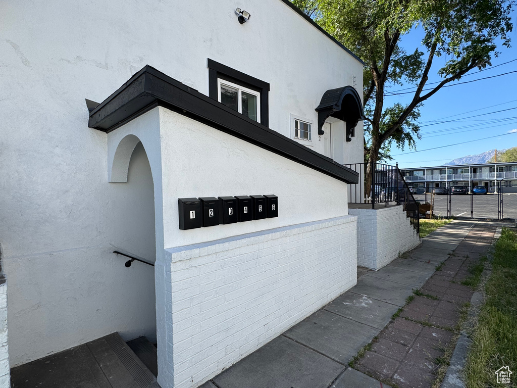 View of side of property featuring mail area and stucco siding