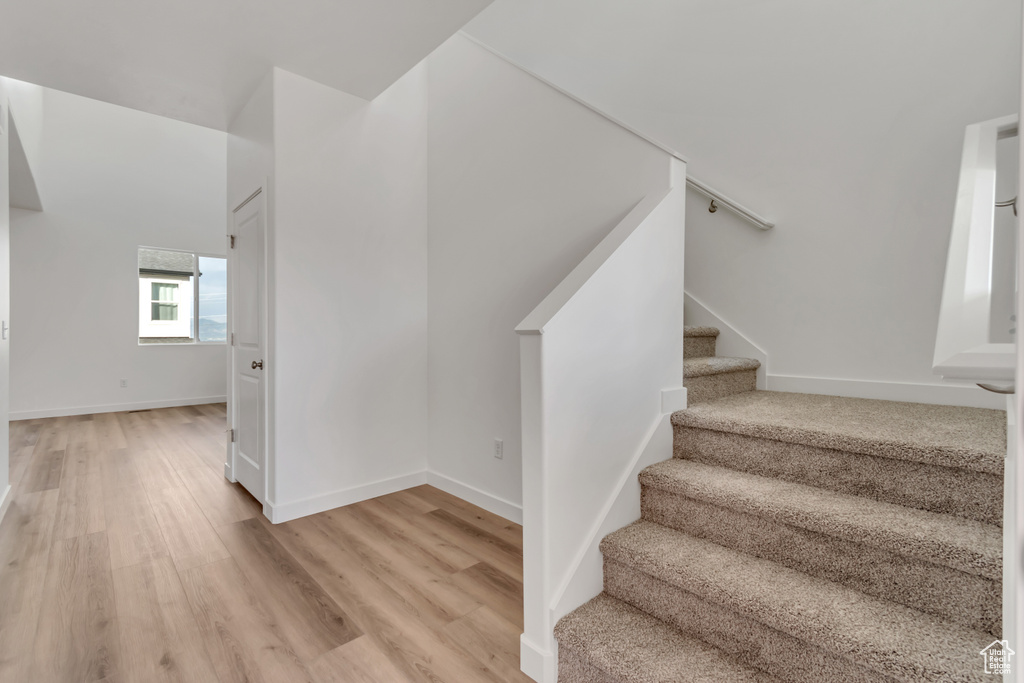 Staircase with wood finished floors and baseboards