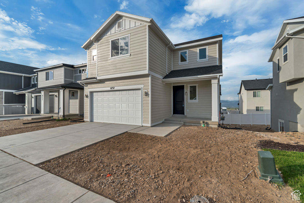 View of front facade with a garage, concrete driveway, and a porch