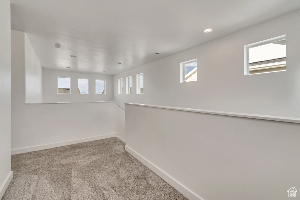 Carpeted spare room with baseboards and recessed lighting