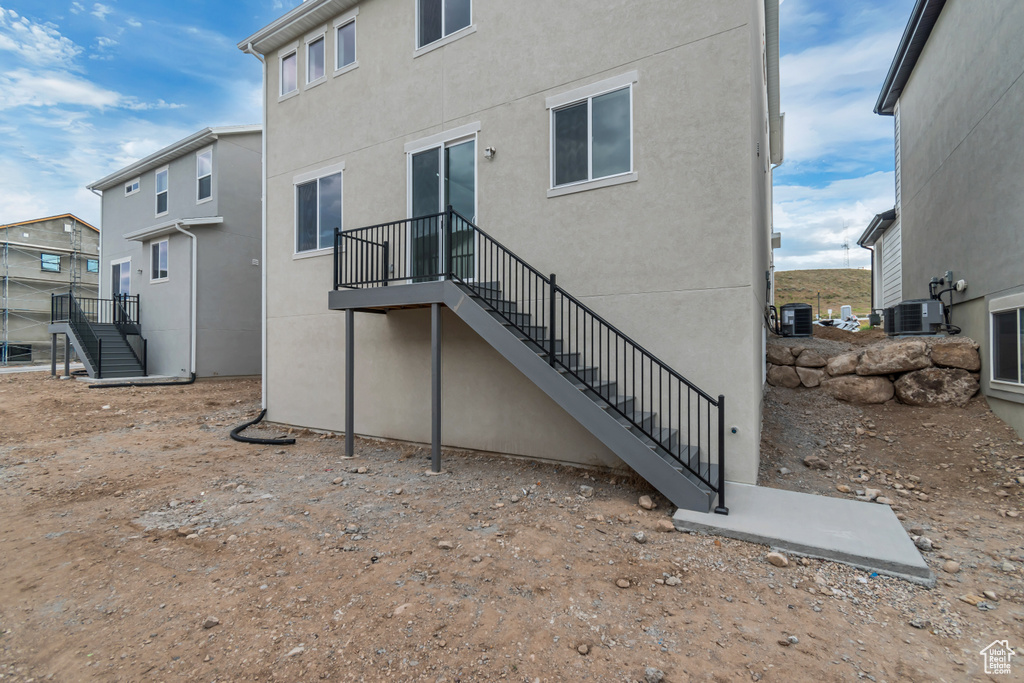Rear view of house featuring stairway and stucco siding