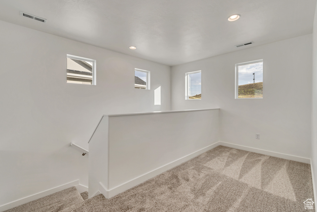 Carpeted empty room with baseboards and recessed lighting