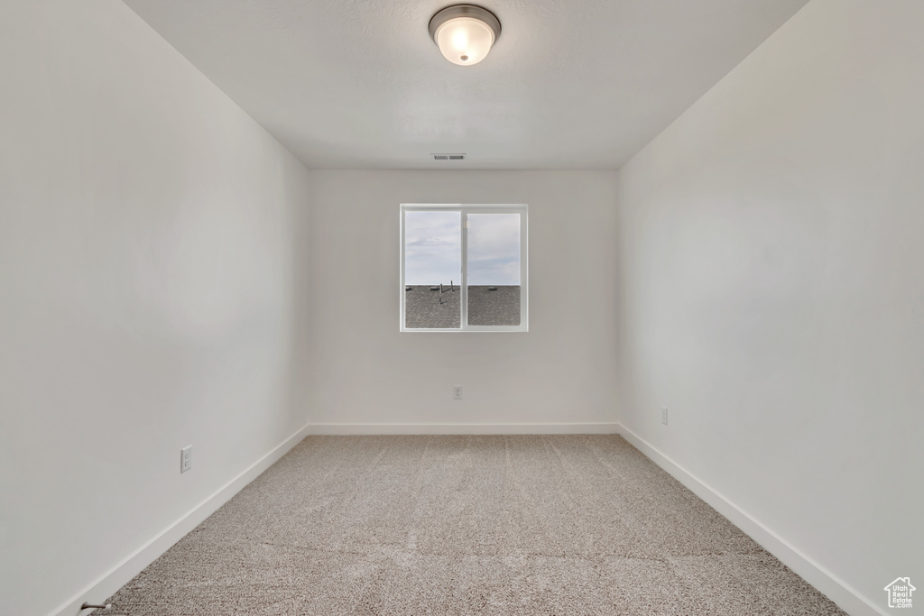 Spare room with light colored carpet and baseboards