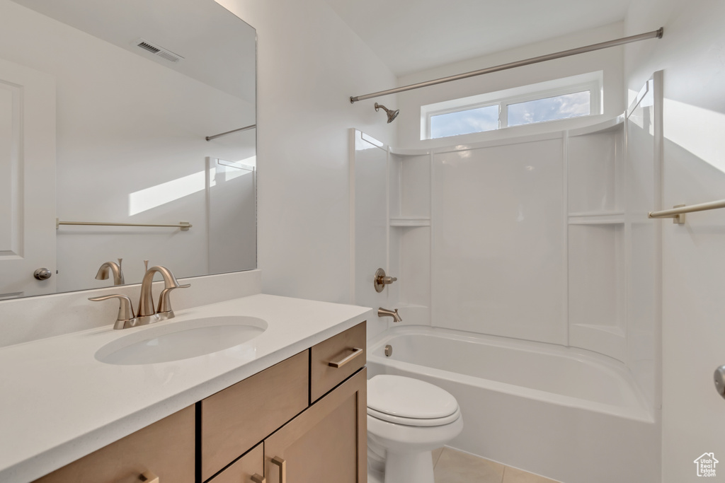 Full bath featuring washtub / shower combination, vanity, and tile patterned floors