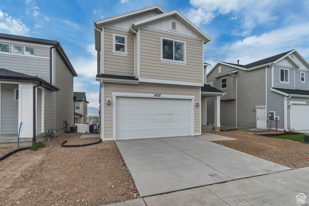 View of front facade featuring board and batten siding, concrete driveway, and an attached garage