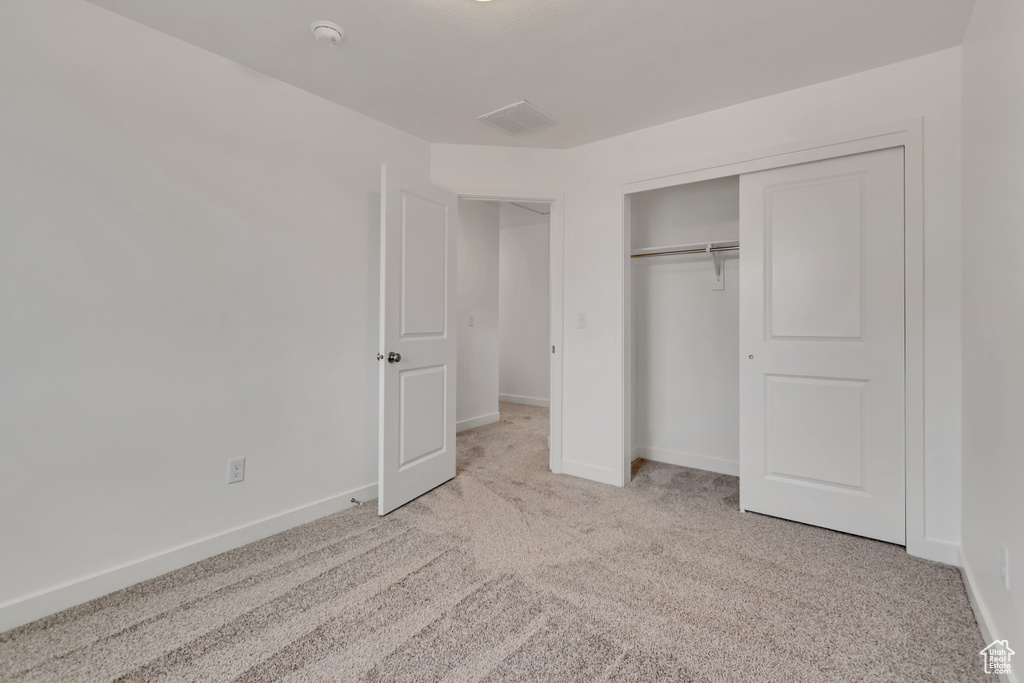 Unfurnished bedroom featuring carpet and a closet