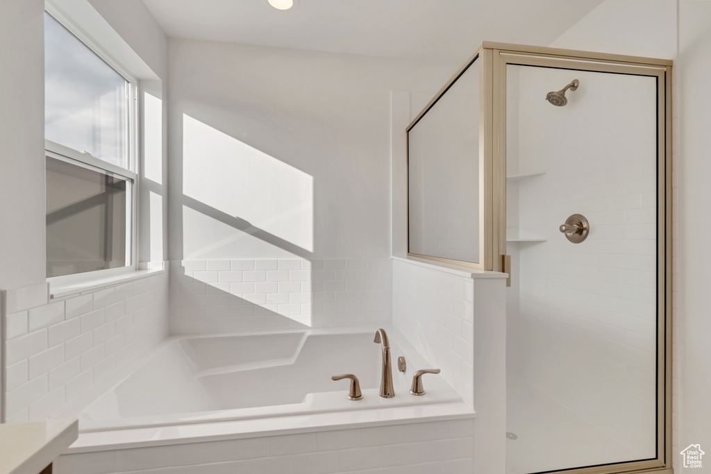 Bathroom with a stall shower and a garden tub
