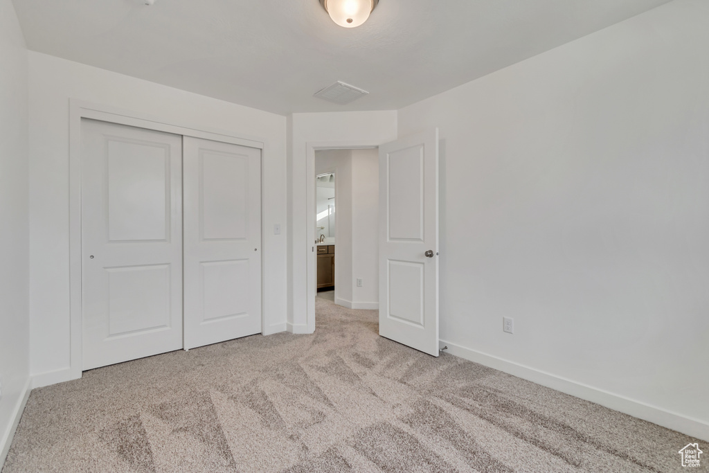 Unfurnished bedroom featuring carpet and a closet