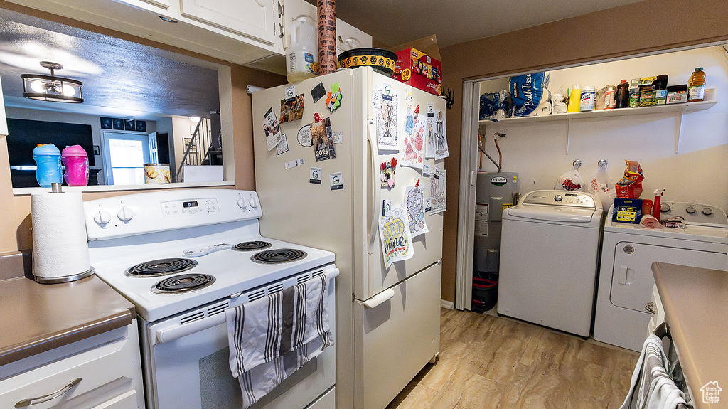 Kitchen featuring white appliances, separate washer and dryer, white cabinets, light wood-style flooring, and water heater
